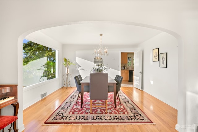 dining space with hardwood / wood-style flooring and a chandelier