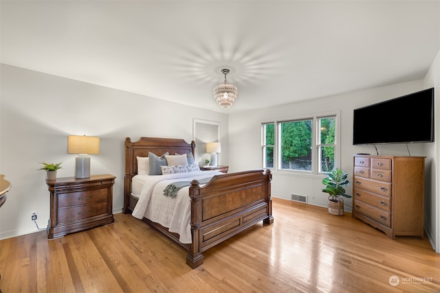 bedroom featuring a chandelier and light wood-type flooring