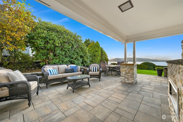 view of patio / terrace featuring an outdoor living space and a water and mountain view