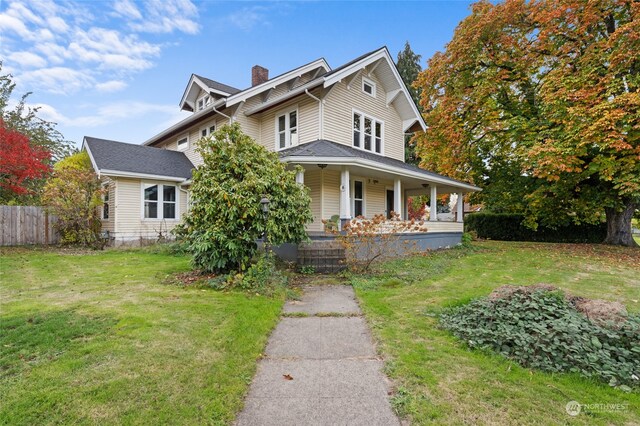 view of front facade featuring covered porch and a front yard