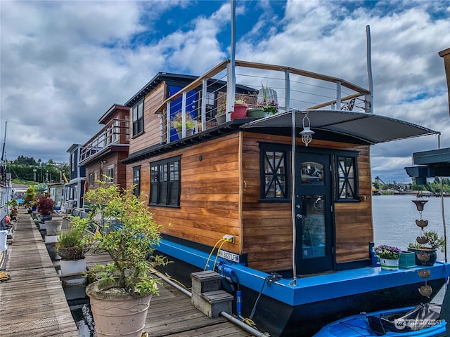 view of side of home with a balcony and a water view