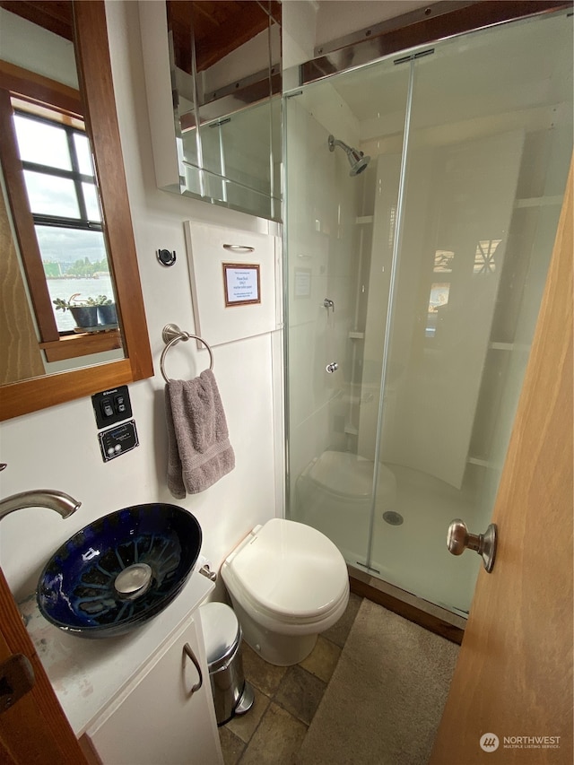 bathroom featuring tile patterned floors, toilet, an enclosed shower, and vanity