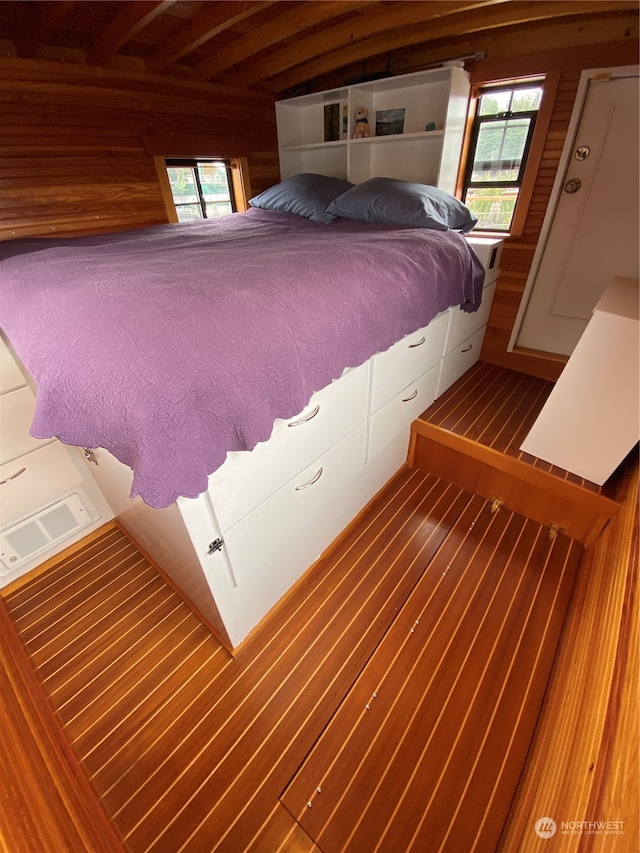 unfurnished bedroom with wood walls and hardwood / wood-style flooring