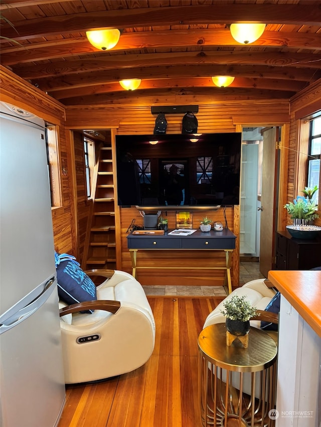 bar with beamed ceiling, hardwood / wood-style floors, refrigerator, wooden walls, and wood ceiling