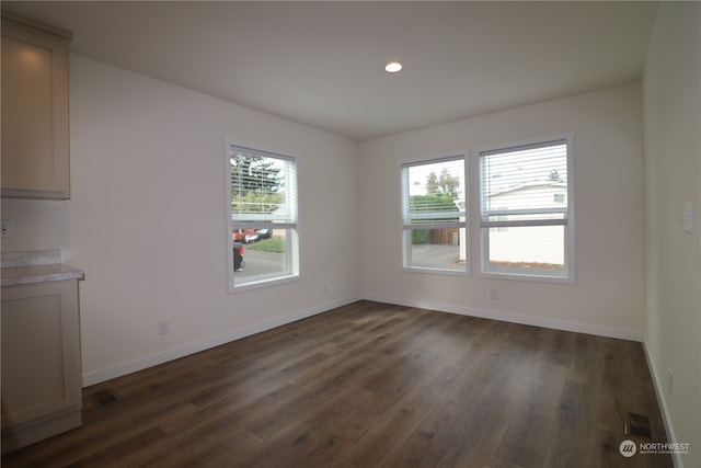 unfurnished dining area with dark wood-type flooring