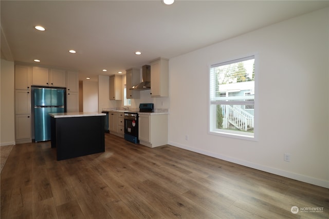 kitchen with a kitchen island, wall chimney range hood, stainless steel appliances, white cabinetry, and dark hardwood / wood-style flooring