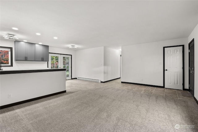 unfurnished living room with a baseboard radiator, light carpet, and french doors