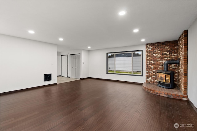 unfurnished living room featuring hardwood / wood-style flooring and a wood stove