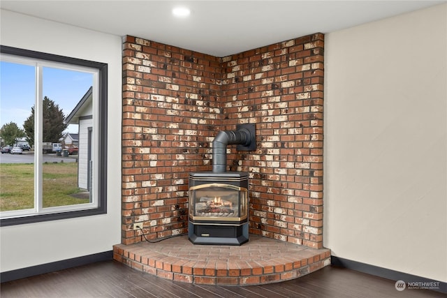 interior details with hardwood / wood-style floors and a wood stove