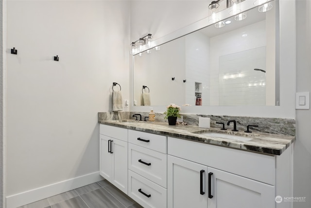 bathroom featuring vanity, a tile shower, and tile patterned flooring