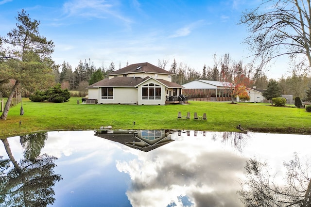 back of house featuring a yard and a water view