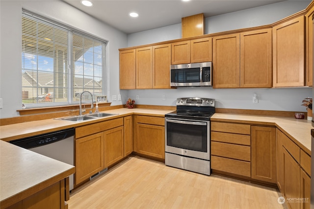 kitchen with light hardwood / wood-style flooring, appliances with stainless steel finishes, and sink