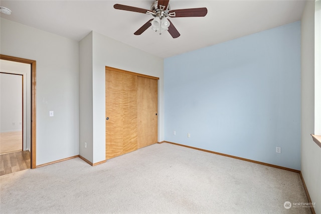 unfurnished bedroom featuring a closet, ceiling fan, and light carpet