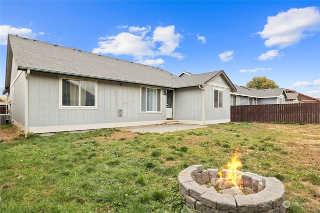 back of property featuring a lawn, a patio area, and a fire pit