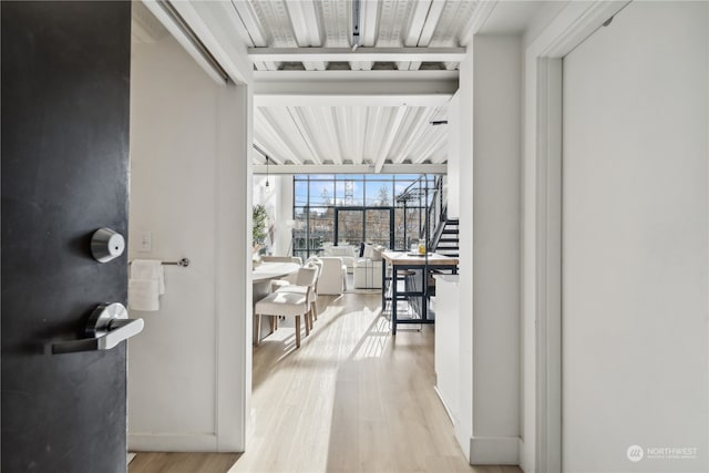 hallway featuring a wall of windows and light hardwood / wood-style floors