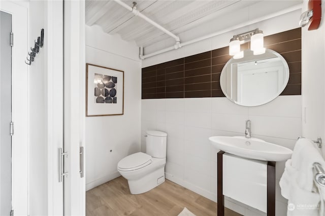 bathroom featuring tile walls, vanity, and wood-type flooring