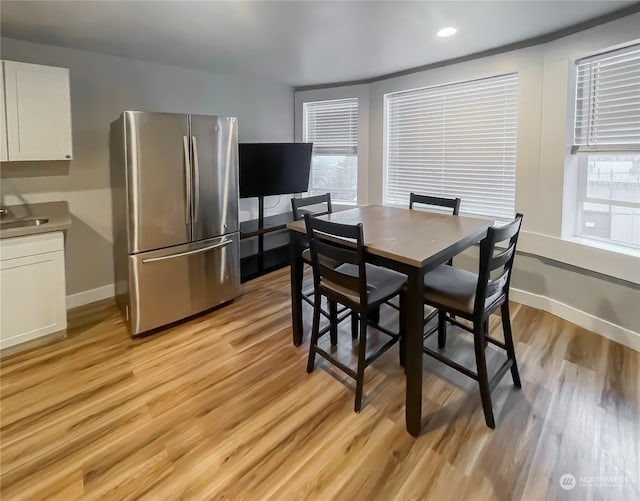 dining space featuring light wood-type flooring and sink