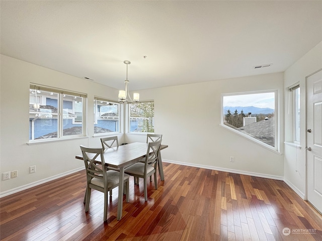 dining space featuring dark hardwood / wood-style flooring and a notable chandelier