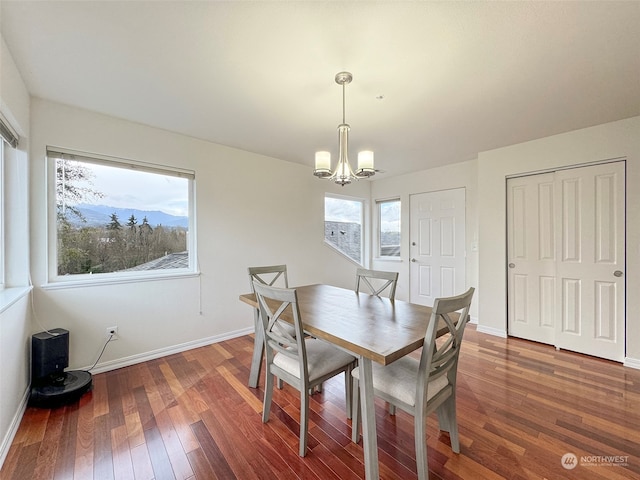 dining area with dark hardwood / wood-style floors and an inviting chandelier