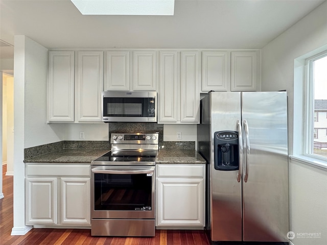 kitchen with white cabinetry, a wealth of natural light, hardwood / wood-style flooring, and stainless steel appliances