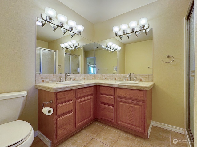 bathroom featuring decorative backsplash, vanity, tile patterned floors, and a shower with shower door