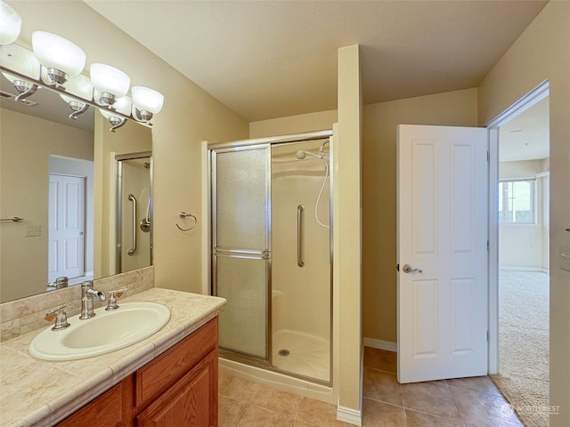 bathroom featuring walk in shower, vanity, and tile patterned flooring