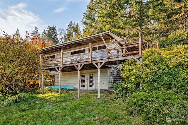 back of house with a lawn and a wooden deck