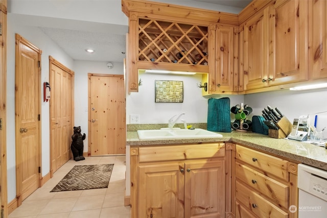 kitchen featuring light tile patterned flooring, dishwasher, sink, and a textured ceiling