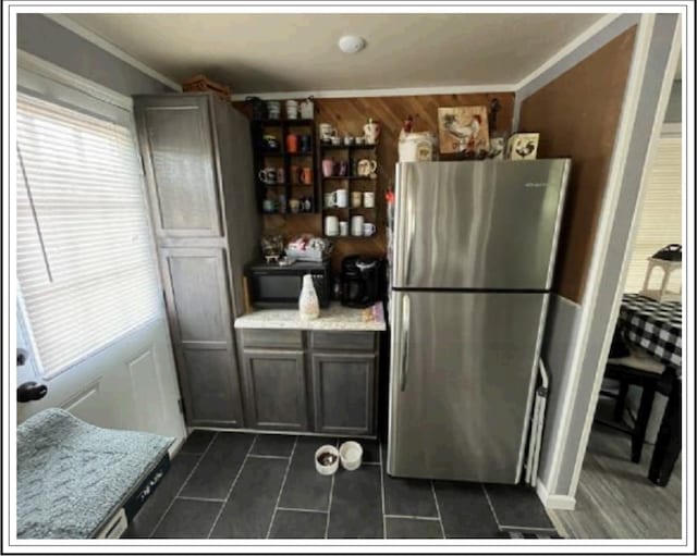 kitchen with ornamental molding and stainless steel fridge