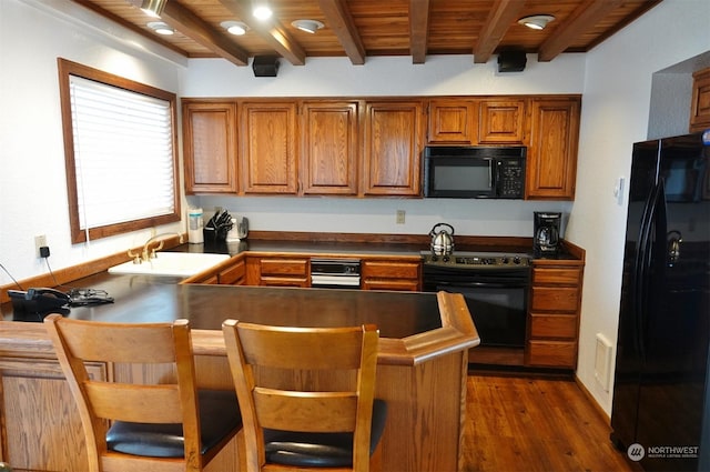 1399 Ocean Shores Blvd SW Unit 2N-E, Ocean Shores, WA 98569 - kitchen featuring black appliances, dark countertops, a peninsula, dark wood finished floors, and brown cabinetry