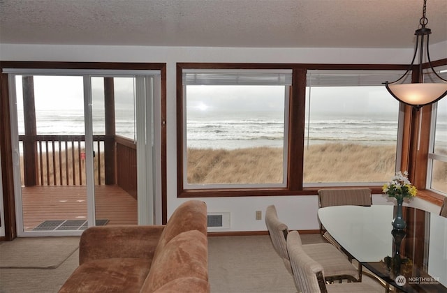 1399 Ocean Shores Blvd SW Unit 2N-E, Ocean Shores, WA 98569 - dining area with carpet flooring, view of water and beach, and a textured ceiling