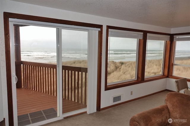 1399 Ocean Shores Blvd SW Unit 2N-E, Ocean Shores, WA 98569 - sunroom with carpet floors, a water view, and a textured ceiling