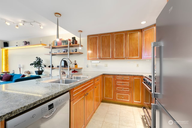 kitchen with stone countertops, stainless steel appliances, sink, light tile patterned flooring, and pendant lighting