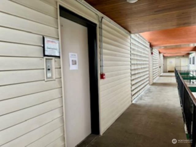 1810 S 118th Unit 401, Seattle, WA 98168 - hallway featuring wood ceiling, carpet floors, and wood walls