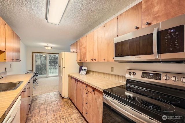 kitchen featuring appliances with stainless steel finishes, a textured ceiling, and sink