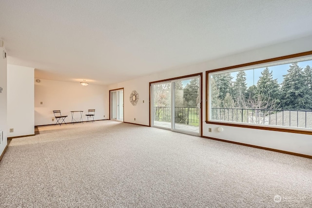 carpeted spare room with a textured ceiling