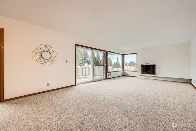 unfurnished living room featuring carpet floors and heating unit