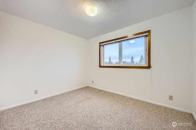 carpeted empty room with a textured ceiling