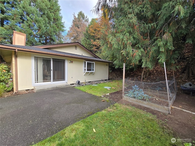 back of house with a yard and a patio