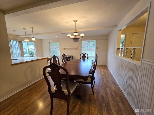 dining room with dark wood-type flooring, beam ceiling, and a chandelier