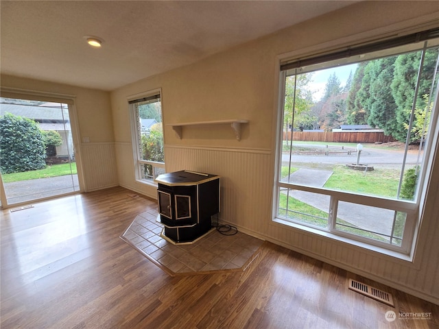 unfurnished living room featuring a wood stove and a wealth of natural light