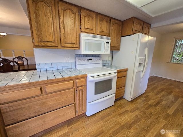 kitchen with tile countertops, hardwood / wood-style floors, and white appliances