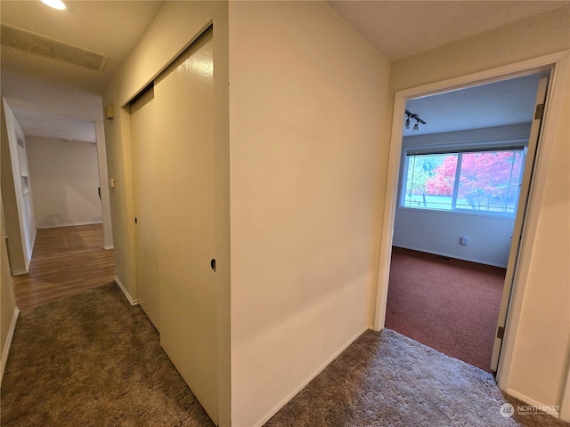 hallway featuring dark colored carpet