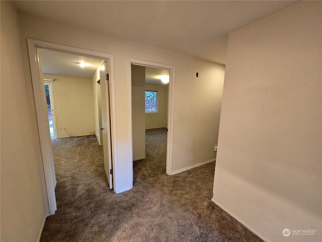 hallway with dark colored carpet