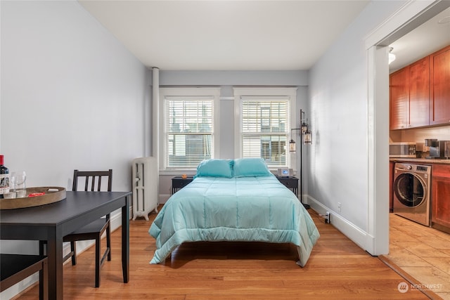 bedroom with radiator, light wood-type flooring, and washer / clothes dryer