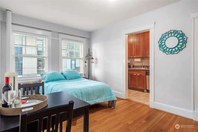 bedroom with light hardwood / wood-style floors and ensuite bath