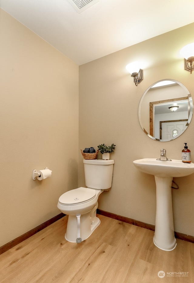 bathroom with wood-type flooring and toilet