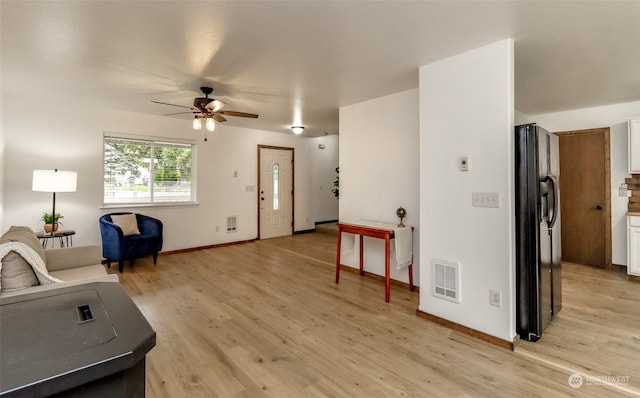 living room featuring light hardwood / wood-style floors and ceiling fan