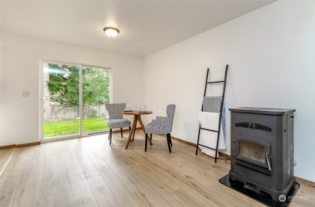 living area with light hardwood / wood-style floors and a wood stove