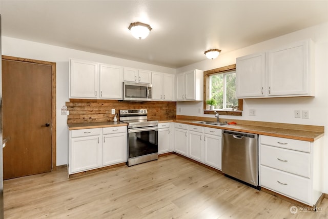 kitchen featuring light hardwood / wood-style flooring, white cabinetry, stainless steel appliances, and sink